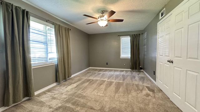 4801 Kent Ave, Groves, TX 77619 - unfurnished bedroom featuring a textured ceiling, carpet floors, baseboards, and ceiling fan