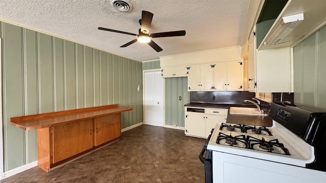 4801 Kent Ave, Groves, TX 77619 - kitchen featuring gas range oven, a ceiling fan, a sink, white cabinetry, and range hood