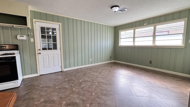 4801 Kent Ave, Groves, TX 77619 - unfurnished dining area featuring a textured ceiling, ornamental molding, tile patterned flooring, and baseboards