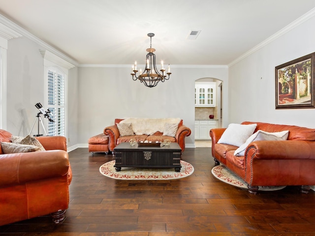 living room featuring dark hardwood / wood-style flooring, an inviting chandelier, and crown molding