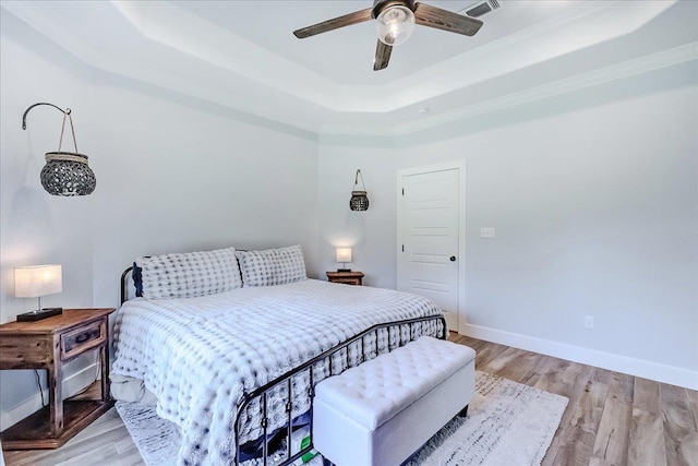 4801 Candlewick Dr, Orange, TX 77630 - bedroom with a tray ceiling, light wood finished floors, a ceiling fan, and ornamental molding