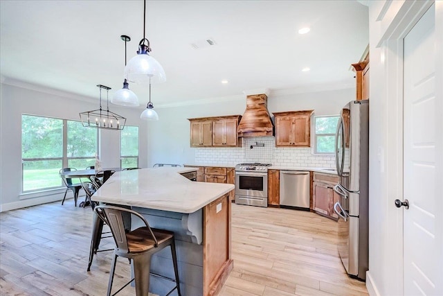 4801 Candlewick Dr, Orange, TX 77630 - kitchen with appliances with stainless steel finishes, custom range hood, a breakfast bar, decorative backsplash, and light wood finished floors