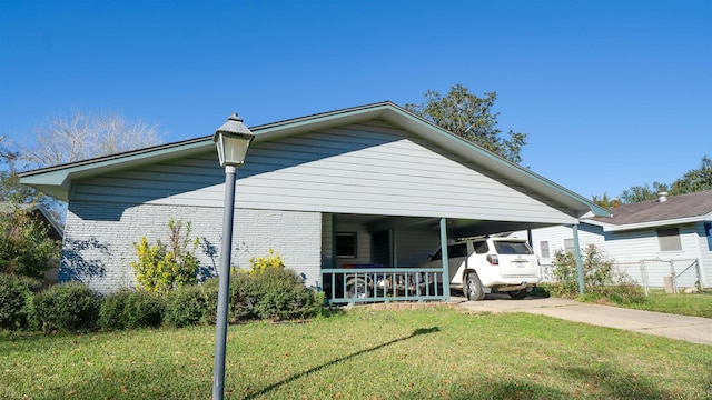 view of front of house featuring covered porch, a carport, and a front lawn