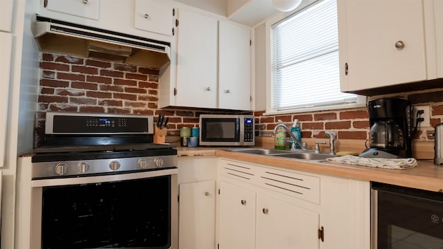 kitchen featuring white cabinets, appliances with stainless steel finishes, wine cooler, and sink