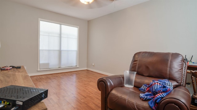 living area featuring ceiling fan and hardwood / wood-style flooring