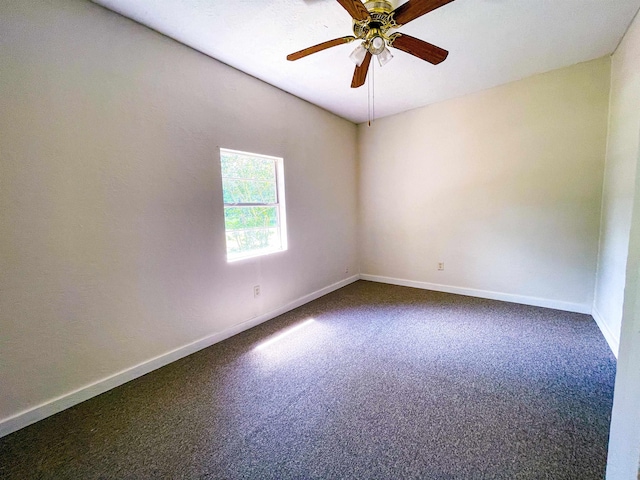 carpeted empty room featuring baseboards and a ceiling fan