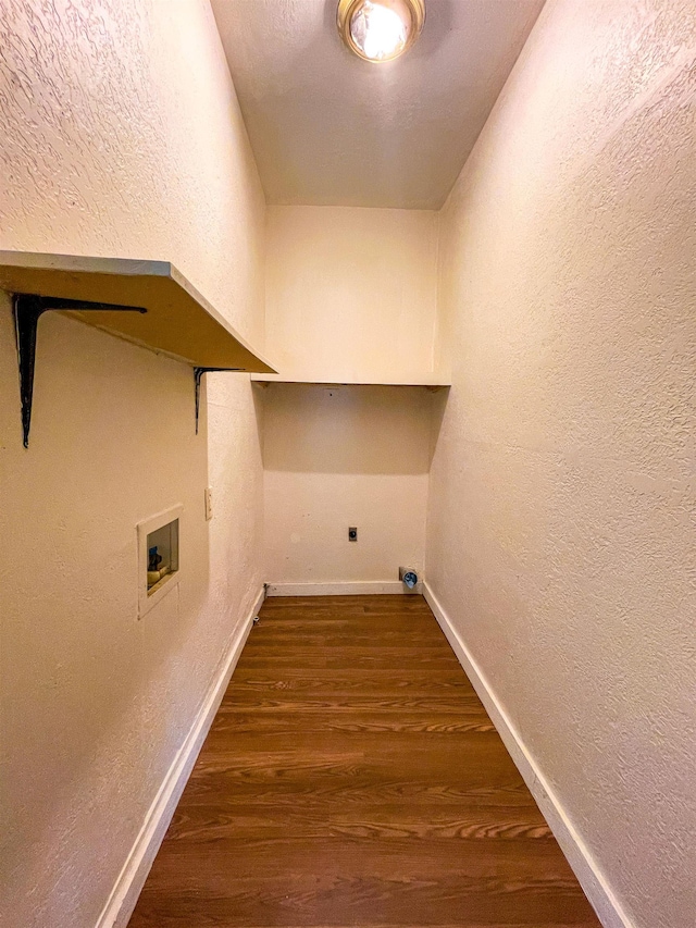 laundry area with wood finished floors, laundry area, a textured wall, baseboards, and hookup for a washing machine