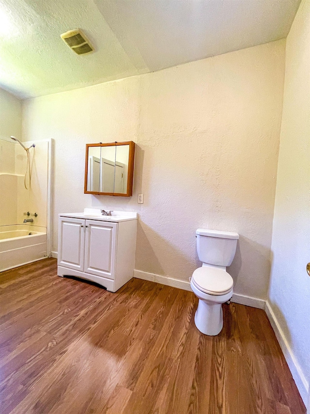 full bath with toilet, wood finished floors, vanity, visible vents, and bathtub / shower combination