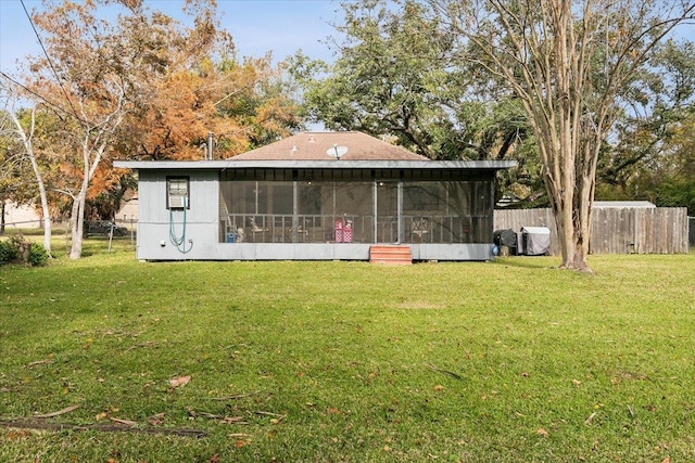 back of property with a yard and a sunroom