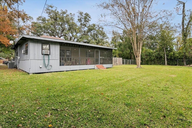 view of yard with central AC, a sunroom, and cooling unit