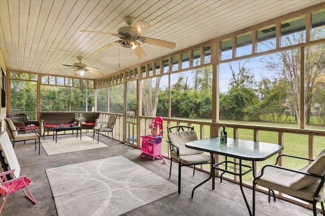 sunroom / solarium featuring ceiling fan, a healthy amount of sunlight, and wood ceiling