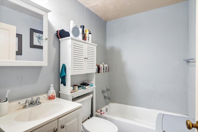 bathroom featuring a textured ceiling, vanity, toilet, and a tub