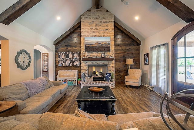 living room featuring wooden walls, a fireplace, high vaulted ceiling, and hardwood / wood-style flooring