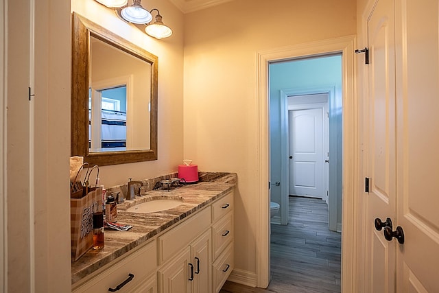 bathroom with toilet, vanity, and hardwood / wood-style flooring