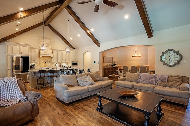 living room featuring beamed ceiling, dark hardwood / wood-style flooring, high vaulted ceiling, and ceiling fan with notable chandelier