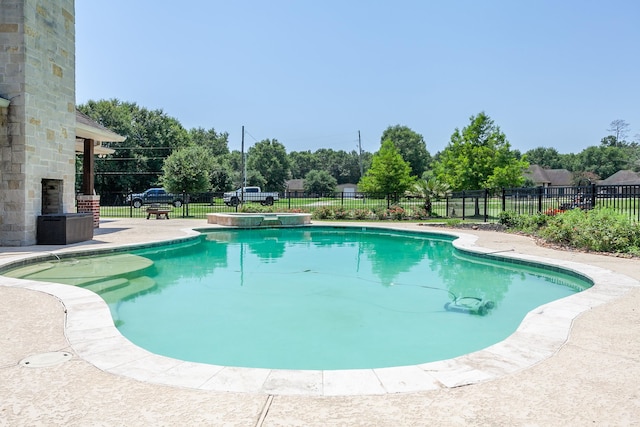 view of pool with a patio area and an outdoor stone fireplace