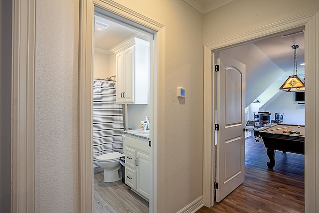 hall with wood-type flooring and ornamental molding