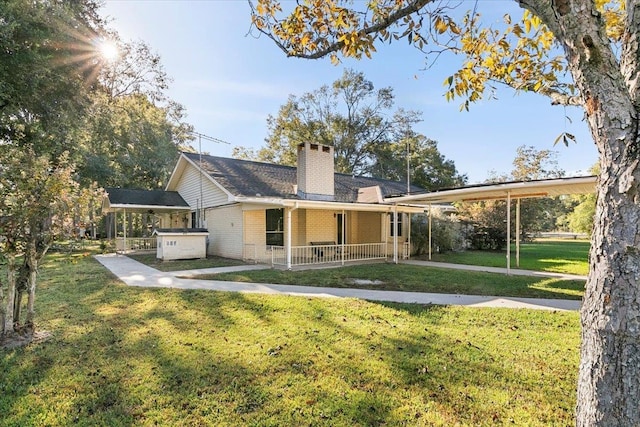 rear view of property with covered porch, a yard, and a hot tub