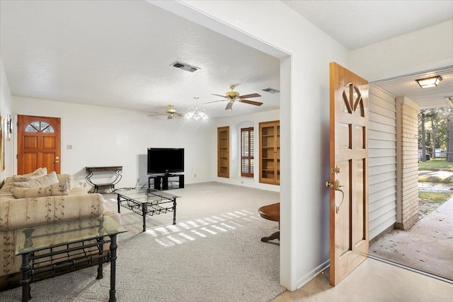 living room featuring light carpet, ceiling fan, and a textured ceiling