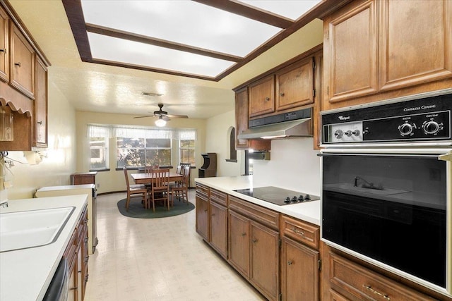 kitchen with ceiling fan, sink, black appliances, and a textured ceiling