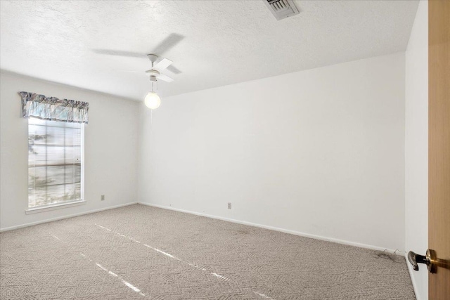 carpeted empty room with ceiling fan and a textured ceiling