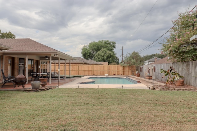 view of swimming pool with ceiling fan, a patio area, and a lawn