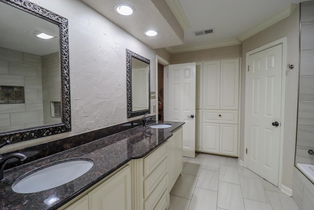 bathroom featuring a washtub, vanity, tile patterned floors, and crown molding