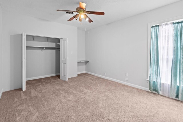 2695 Sandlin St, Beaumont, TX 77707 - unfurnished bedroom with carpet floors, multiple windows, a closet, and a ceiling fan