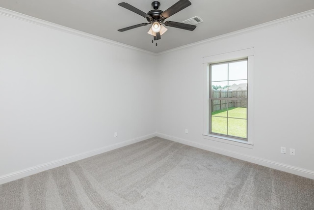 empty room with carpet floors, visible vents, baseboards, and ornamental molding