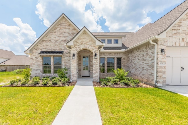 view of front of home featuring an attached garage, a front lawn, brick siding, and roof with shingles