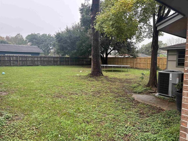 view of yard featuring cooling unit and a trampoline