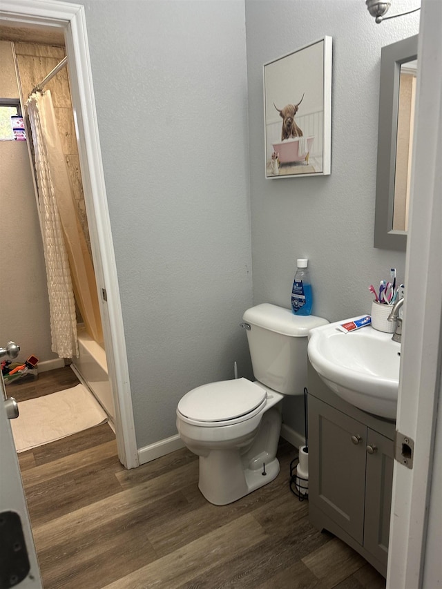 full bathroom featuring shower / bathtub combination with curtain, toilet, vanity, and hardwood / wood-style flooring