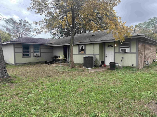 back of house with cooling unit and a yard