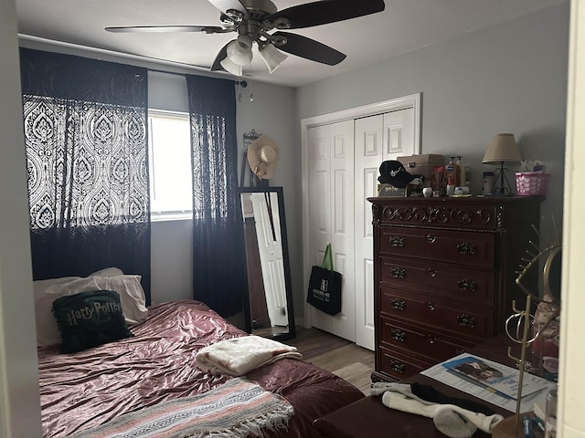 bedroom featuring ceiling fan, a closet, and hardwood / wood-style flooring