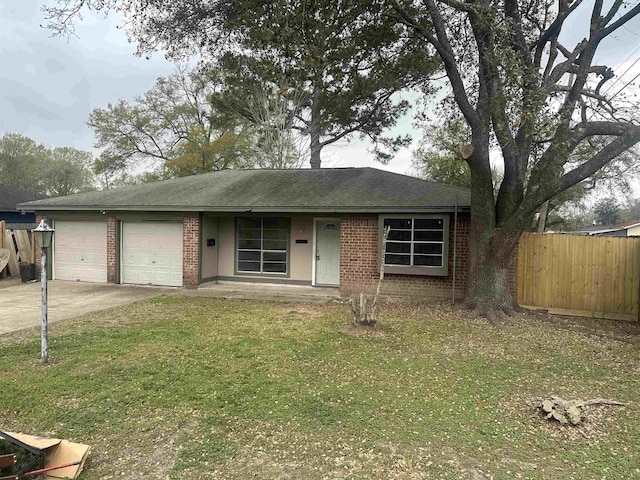 single story home with fence, concrete driveway, a front yard, a garage, and brick siding