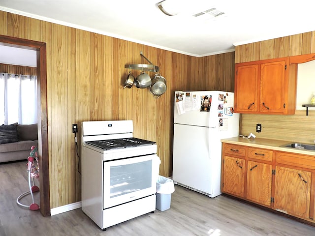 kitchen with brown cabinets, light countertops, white appliances, and visible vents