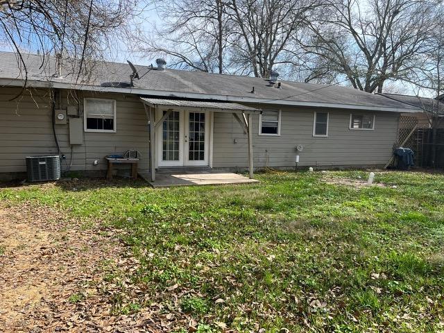 back of property with a yard, a patio, central AC, and french doors