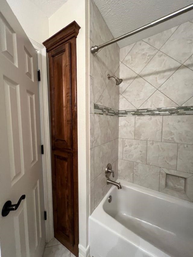 full bathroom featuring a textured ceiling, bathtub / shower combination, and tile patterned floors