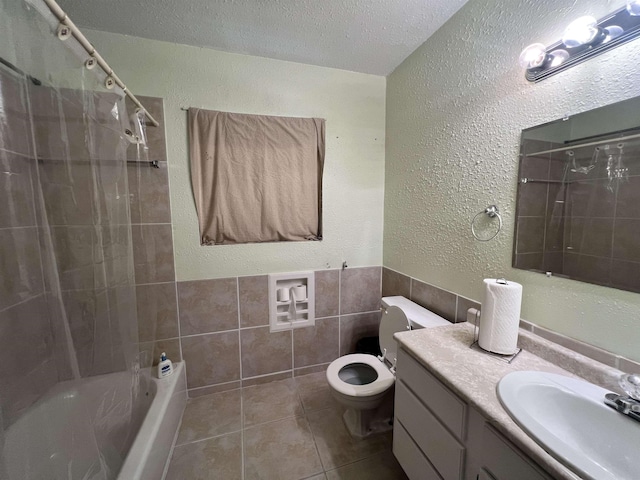 3265 N Willowood Ln, Beaumont, TX 77703 - full bathroom featuring tile patterned floors, washtub / shower combination, a textured wall, vanity, and tile walls