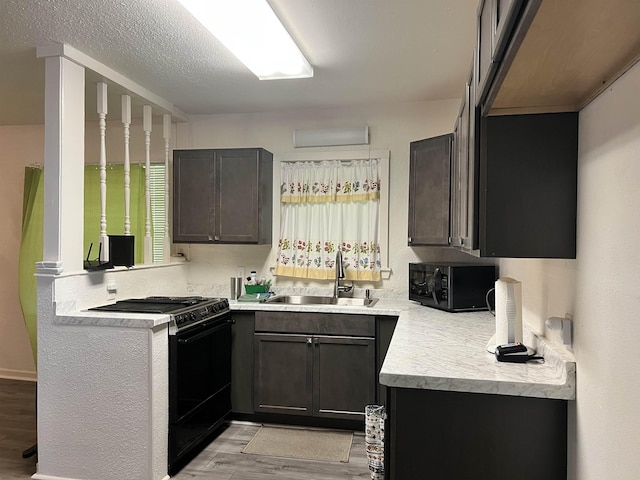 3265 N Willowood Ln, Beaumont, TX 77703 - kitchen with black appliances, light wood finished floors, and light countertops