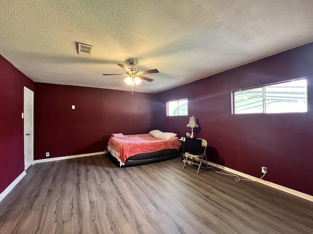 3265 N Willowood Ln, Beaumont, TX 77703 - bedroom featuring wood finished floors, a textured ceiling, and a ceiling fan