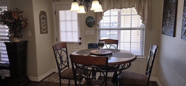 dining area with a notable chandelier, baseboards, and wood finished floors