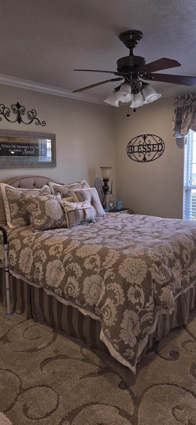 carpeted bedroom with a textured ceiling, a ceiling fan, and ornamental molding