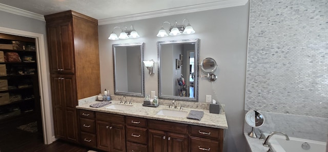 full bathroom featuring a sink, ornamental molding, double vanity, and a bath