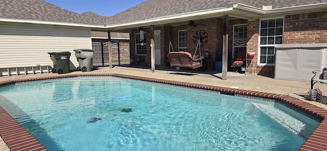 view of swimming pool with a patio area, a fenced in pool, a ceiling fan, and fence