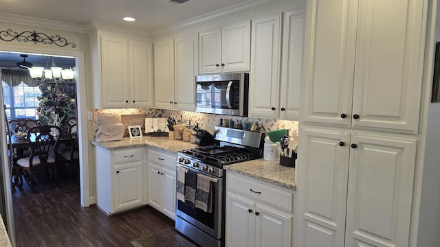 kitchen with dark wood-style floors, white cabinetry, stainless steel appliances, and tasteful backsplash