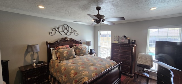 bedroom with a ceiling fan, dark wood-type flooring, crown molding, and a textured ceiling