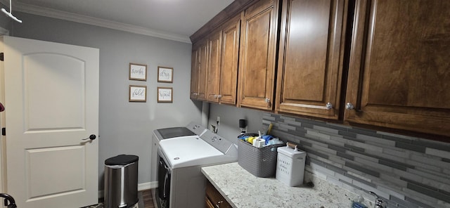 laundry area featuring separate washer and dryer, cabinet space, baseboards, and ornamental molding