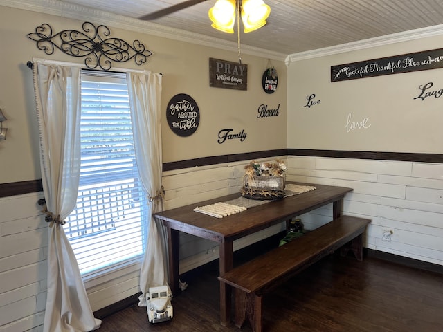 dining space with dark hardwood / wood-style floors, ceiling fan, ornamental molding, and wooden walls