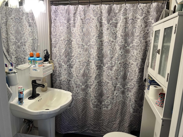 bathroom featuring a shower with shower curtain and sink